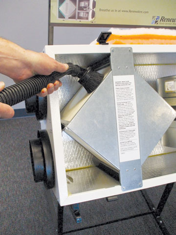 Technician performing ERV maintenance and cleaning on a RenewAire system